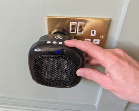 The Swan 700W plug-in mini fan heater plugged into a wall
