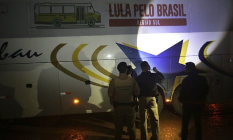 Police investigate a bus used by the campaign caravan carrying Brazil’s former President Luiz Inacio Lula da Silva Tuesday.