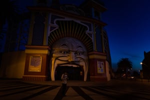 A man outside a deserted Luna Park as curfew approaches in Melbourne on 10 September.