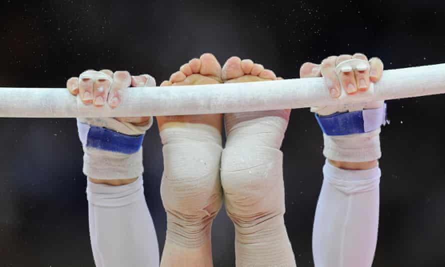 A gymnast’s hands and feet on the uneven bars during the Women’s artistic gymnastics qualification at London 2012