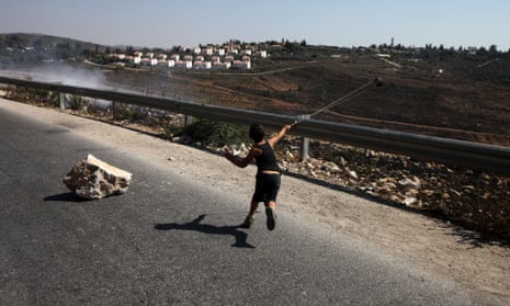 A Palestinian boy hurls a stone during a protest against the confiscation of Palestinian land to expand Jewish settlements in Nabi Saleh near Ramallah.