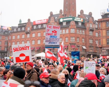 People in Copenhagen hold up signs of solidarity with Greenland