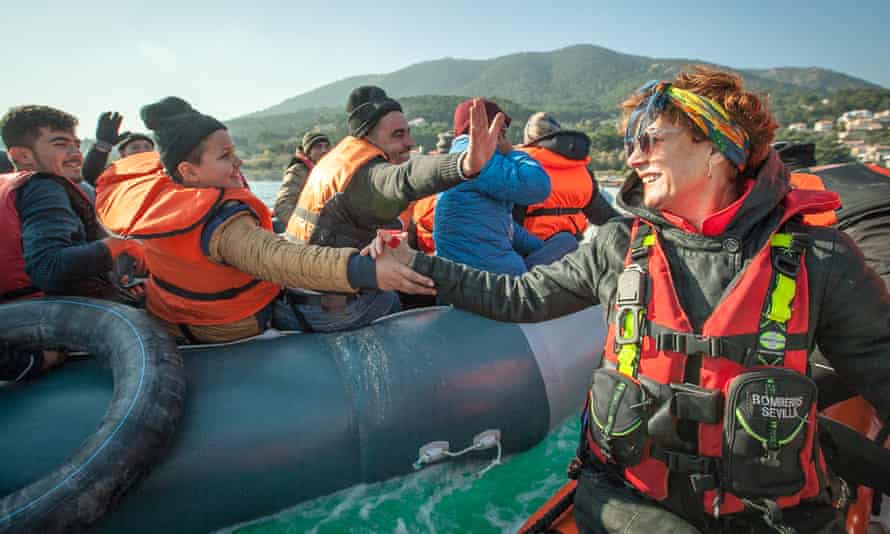 Sarandon greets refugees arriving on a rubber dinghy.