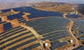 Aerial shot of a solar farm on a barren hill