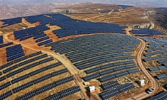 Aerial shot of a solar farm on a barren hill