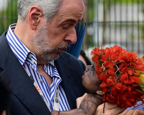 COP30 President Andre Correa do Lago holds a Munduruku Indigenous toddler during a blockade of the conference on Friday.