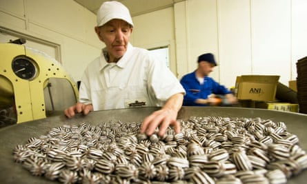 Older worker sorting sweets in factory