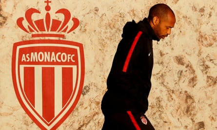 Thierry Henry walks past Monaco badge.