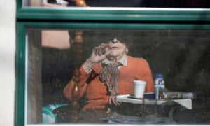 A resident waves from her room inside a long-term care facility in Quebec, following a number of coronavirus deaths.