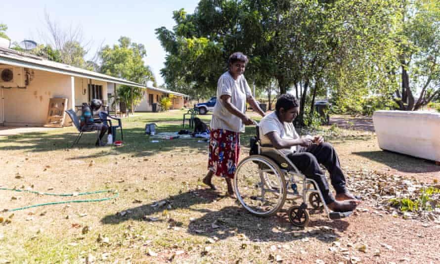 Steele pushes Josias in his wheelchair, with his grandfather Philip Morris in background