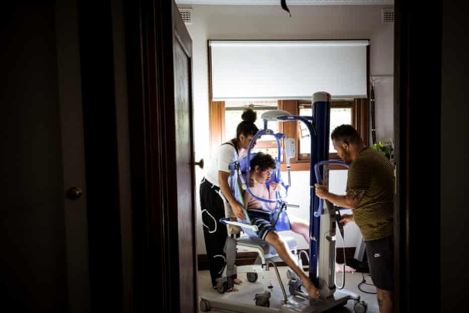 Dlabik and her partner, Morganne Blackburn, lifting Elijah into his wheelchair with a hoist.