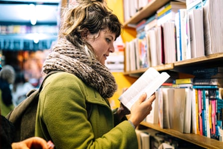 Woman wearing scarf reading book in library