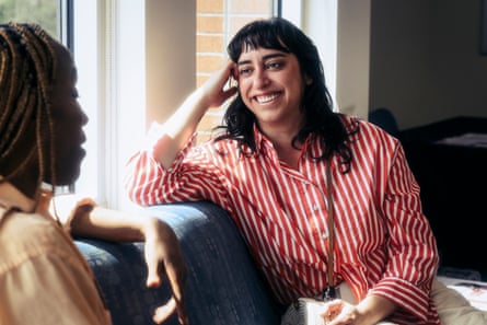 Happy woman talking with friend in waiting room at doctor’s office