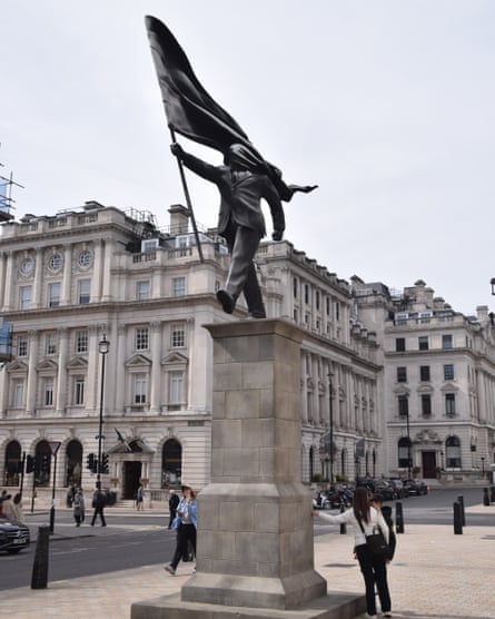 The statue and tall plinth with grand buildings in the background