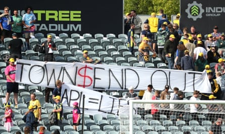 Protestors hold a banner in the 20th minute as fans walk out of the stadium during the Central Coast Mariners’ game against Sydney FC.
