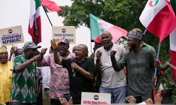 A group of men at a protest in Nigeria in front of flags