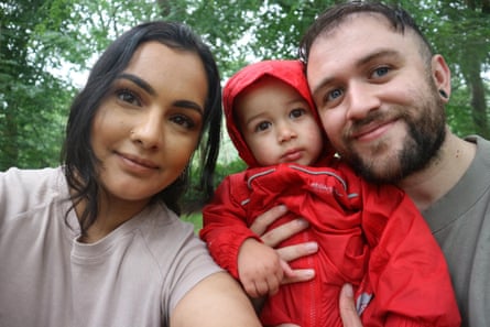 A family, with a toddler in a red coat.