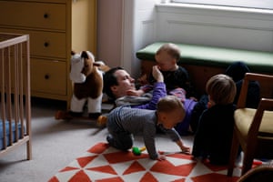 Joel takes a moment to relax with the children in the baby's room. Reed sits on his father's chest and Aven tries to snatch a toy from Francis' hand.