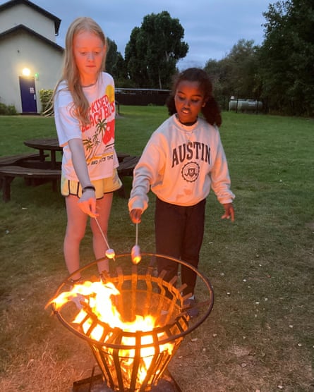 Two children toast marshmallows on an open fire