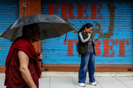 A monk walks past a closed shop with ‘Free Tibet’ written on it