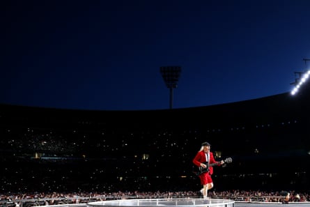 Angus Young on stage in a red jacket and shorts