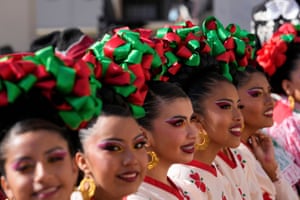 a row of women with red and green ribbons in their hair