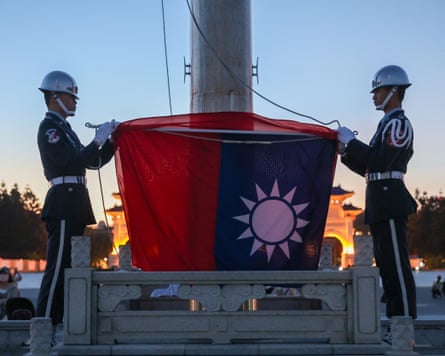 two honour guards folding the Taiwanese flag during a flag-lowering ceremony in Taipei