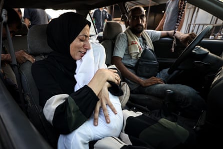 A Palestinian woman holds the body of a child killed in an Israeli attack on Musa Bin Nusayr School in Gaza City’s ed-Derec neighborhood on Friday as she brings the body to al-Ahli Baptist Hospital for a funeral process.