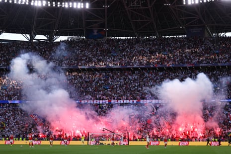 The PSG fans let off flares whilst players of Arsenal are dejected following Ousmane Dembele’s equaliser.