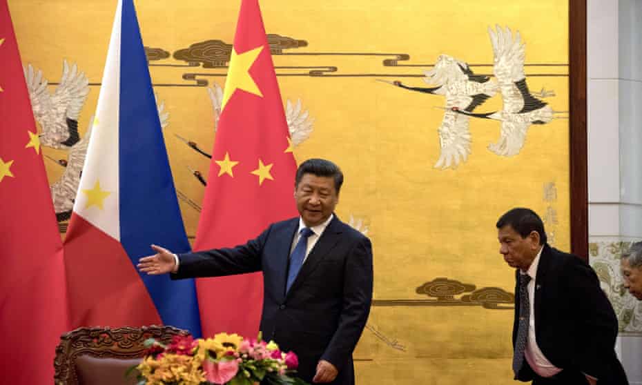 The Philippine president, Rodrigo Duterte, is shown the way by his Chinese counterpart, Xi Jinping, before a signing ceremony in Beijing, China.