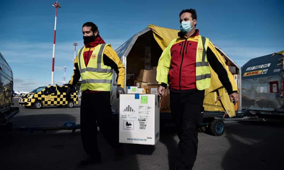 Workers carries boxes containing the Pfizer-BioNTech Covid-19 vaccine at an airport in Thessaloniki