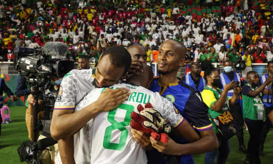 Comoros players, including stand-in keeper Chaker Alhadhur, embrace after the final whistle.