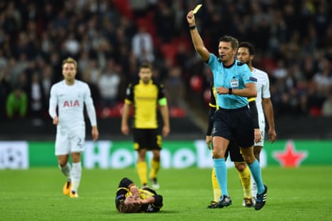The referee flashes a second yellow card in the direction of Jan Vertonghen, and then a red card, as Borussia Dortmund’s Mario Goetze clutches his face.