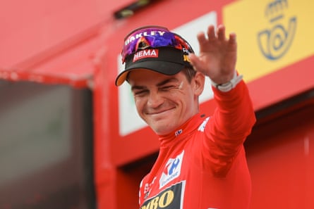 Sepp Kuss, wearing the overall leader’s red jersey, celebrates on the podium after the stage