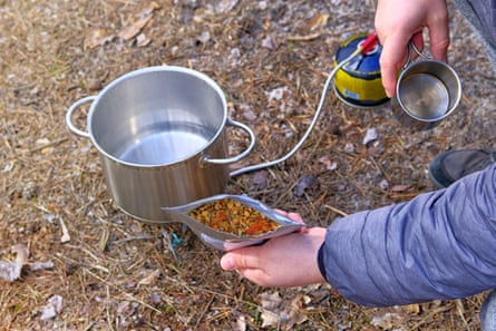 Traveler is eating freeze dried food during camping.