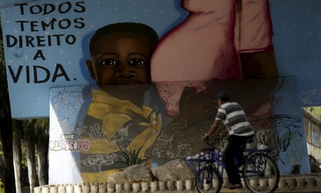 A man walks in front of a graffiti of pregnancy on an overpass in Recife, Brazil, 4 February 2016. The graffiti reads, ‘We all have a right to live’. 