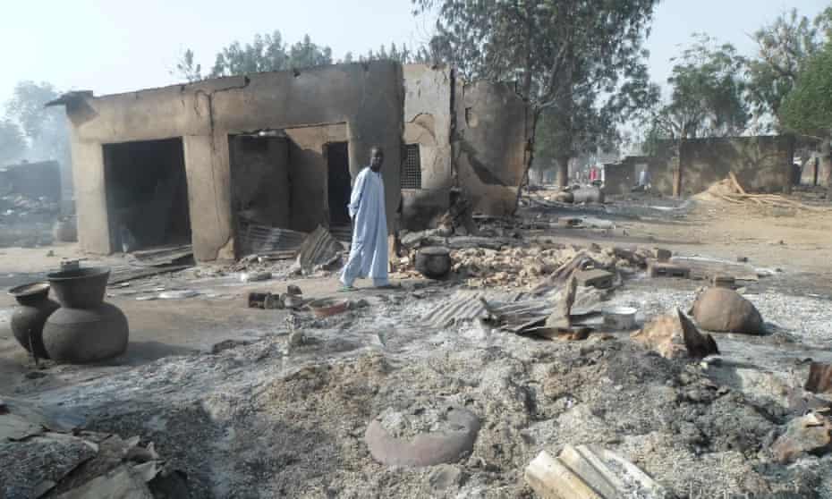A man walks past burnt out houses following an attack by Boko Haram on Dalori village.