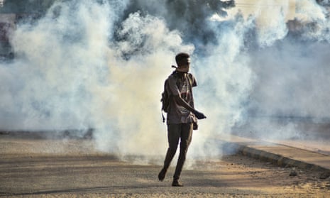 A Sudanese man is engulfed by teargas fired by security forces during demonstrations against a military takeover.