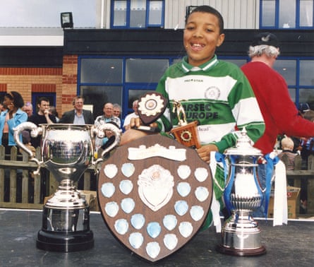 A young Troy Deeney with football trophies.