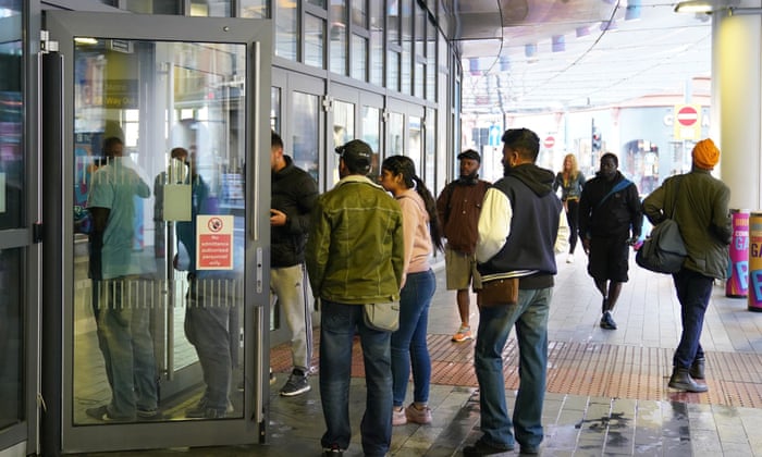 Passengers wait for the doors to open at 7AM at Birmingham New Street station.
