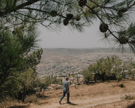 Daoud Nassar walks on his land illegal Israeli settlements in a valley beyond
