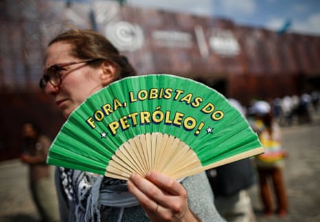 Protesters from the global "Debt for Climate" movement demonstrate, in BelemA woman holds a fan with a message that reads "Oil lobbyists out", as protesters from the "Debt for Climate" movement demonstrate to demand the cancellation of what they call illegitimate debt of the Global South, while the UN Climate Change Conference (COP30) is underway, in Belem, Brazil, November 11, 2025. REUTERS/Adriano Machado
