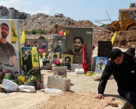 A relative reacts at a temporary cemetery housing graves of Hezbollah fighters and other Lebanese people killed in Israeli attacks in Choueifat, Lebanon