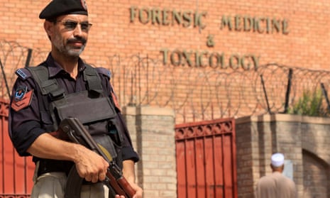 A Pakistani policeman stands guard outside a mortuary where the body of Tahir Ahmad Naseem was taken.