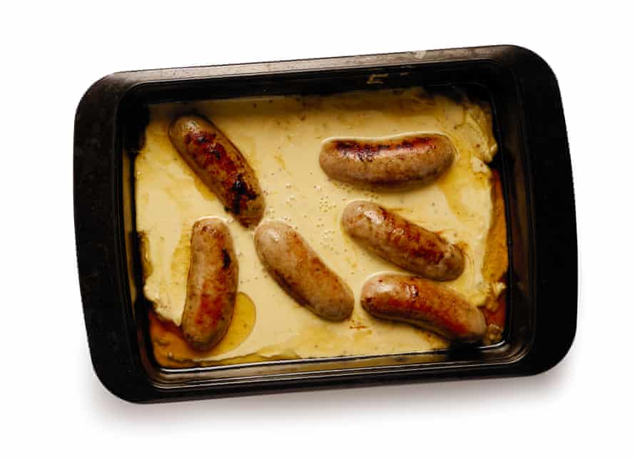 Batter mixture and sausages in baking tin