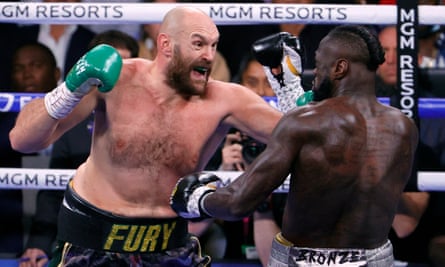 Tyson Fury (left) and Deontay Wilder trade blows in the first round.