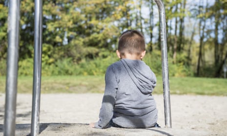 A boy sitting alone in a playground