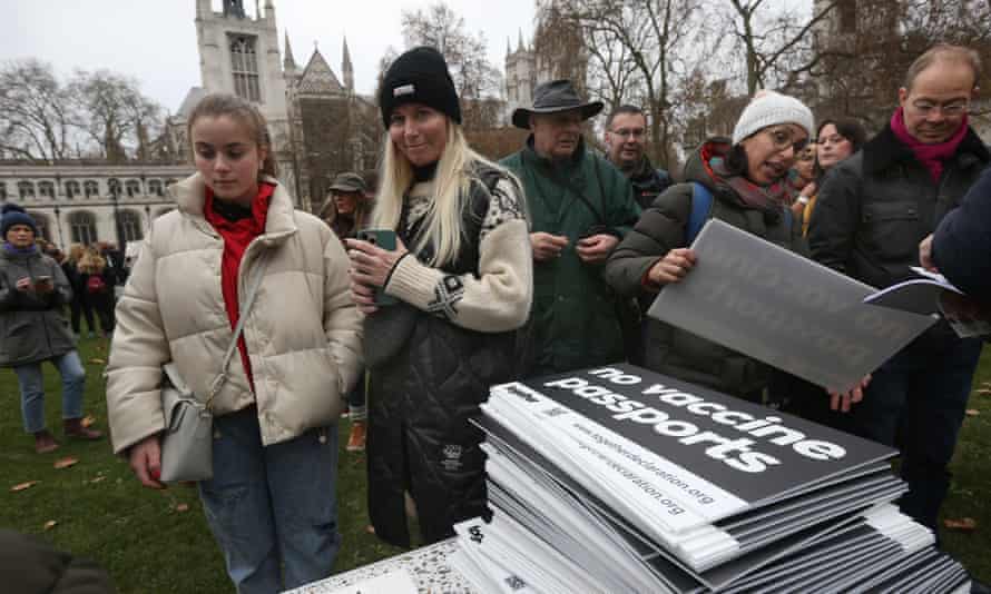 Protesters queue to get no-vaccine passport boards in Parliament Square.