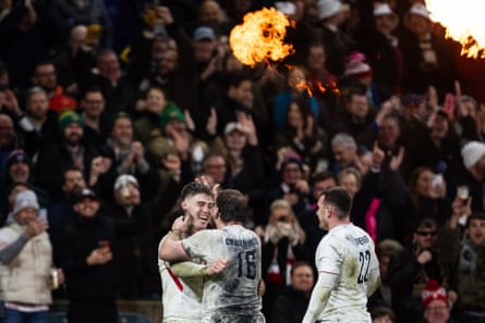 England players celebrate a try with fans looking on in the background at Twickenham.
