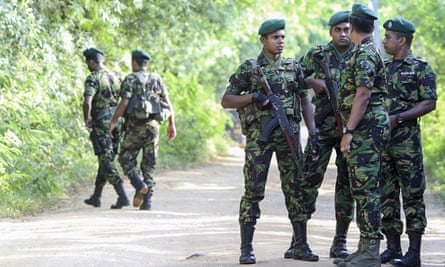 Security personnel patrol outside a polling station in Weerawila, Sri Lanka